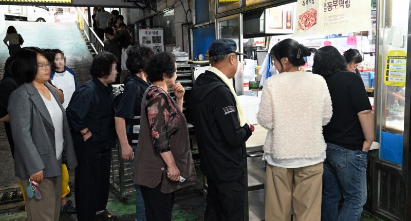 피자설기를 사기 위해 전통시장 떡집 앞에 줄을 선 방문객들